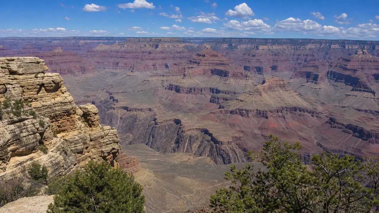 Wide view of layered rock formations and deep ravines from the Grand Canyon's South Rim.