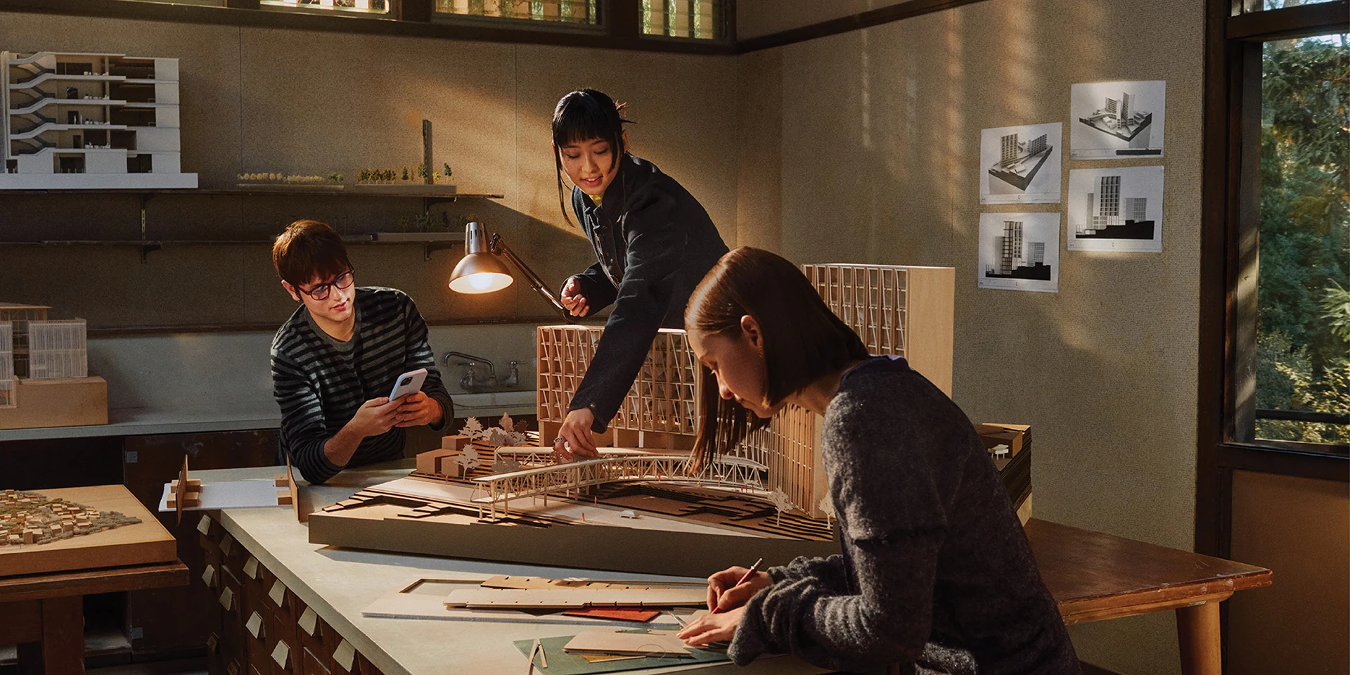 Students collaborating around an architectural model on campus