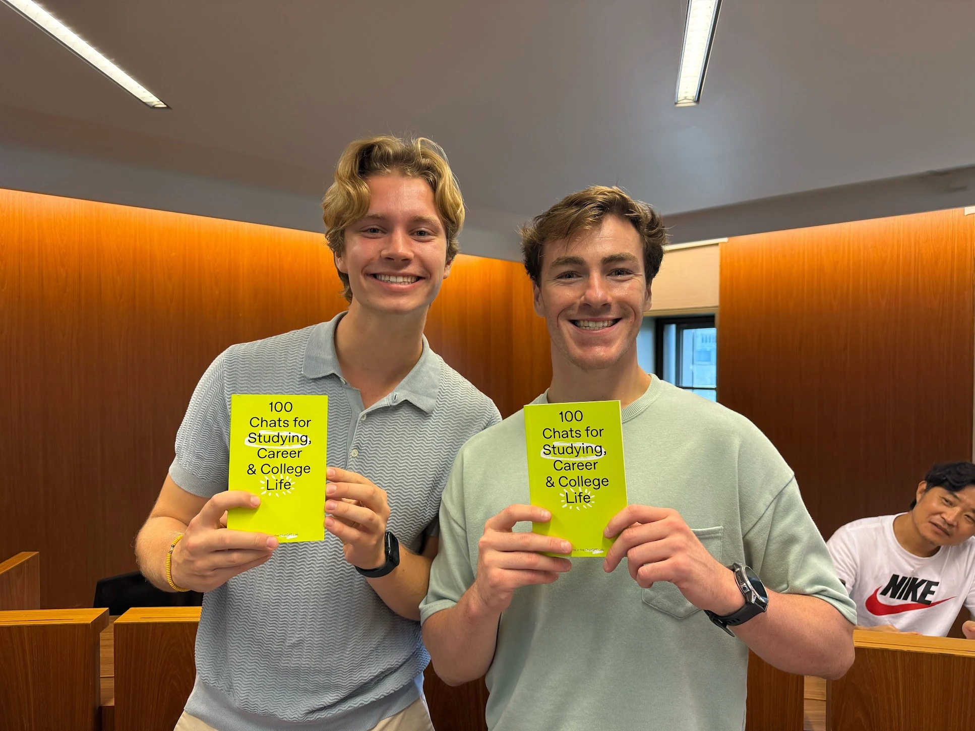 Students holding cards from the 100 Chats project